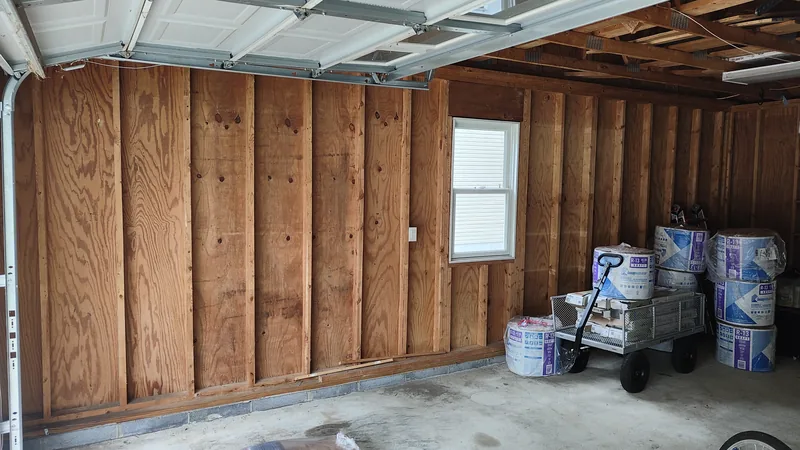 Bare garage wall before insulation and shelving