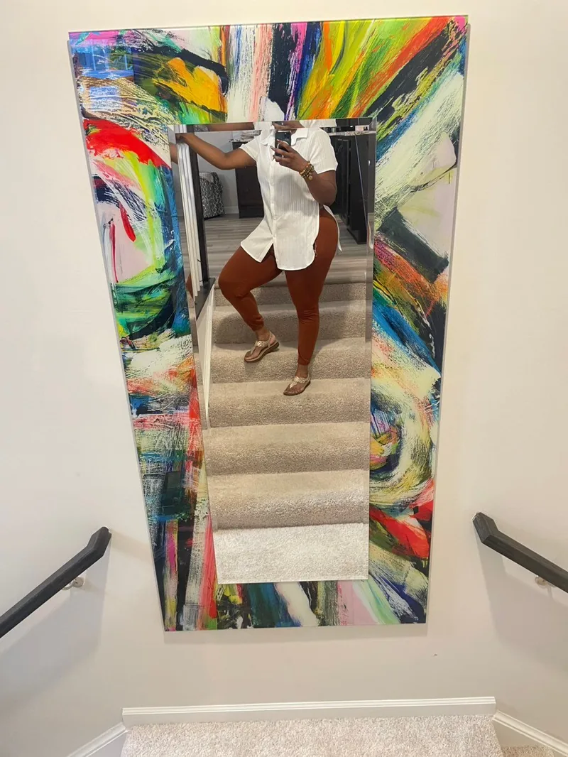 Oversized rectangular mirror mounted vertically above a staircase